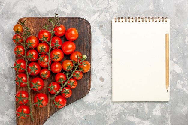 Vue de dessus tomates cerises fraîches légumes entiers mûrs sur une surface blanche