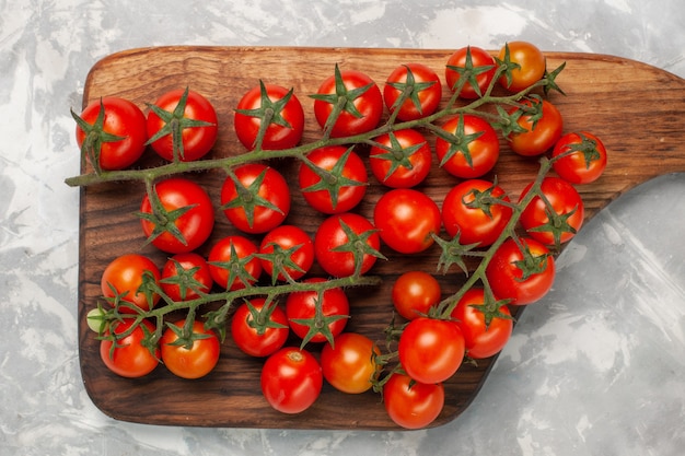 Vue de dessus tomates cerises fraîches légumes mûrs sur une surface blanche