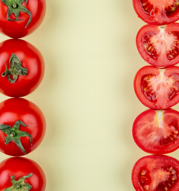 Photo gratuite vue de dessus des tomates sur les côtés gauche et droit sur une surface jaune avec copie espace