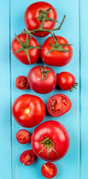 Vue de dessus des tomates coupées et entières sur la surface bleue