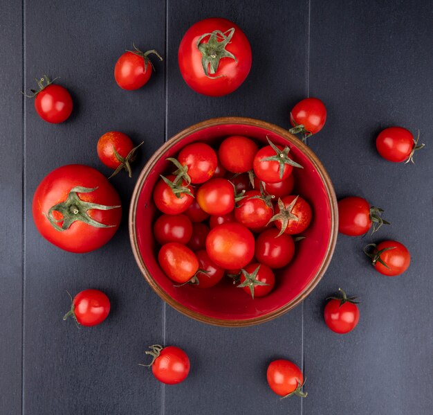 Vue de dessus des tomates dans un bol et sur une surface noire