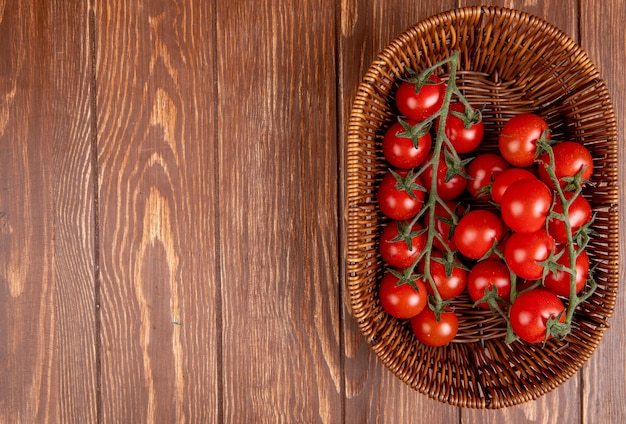 Photo gratuite vue de dessus des tomates dans le panier sur le côté droit et la surface en bois avec copie espace