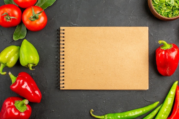 Vue de dessus tomates légumes frais et poivrons sur sol sombre salade couleur repas mûr