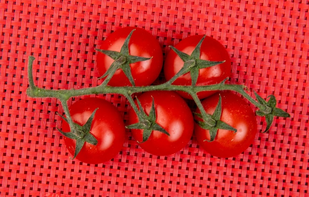 Vue de dessus des tomates sur une surface en tissu rouge