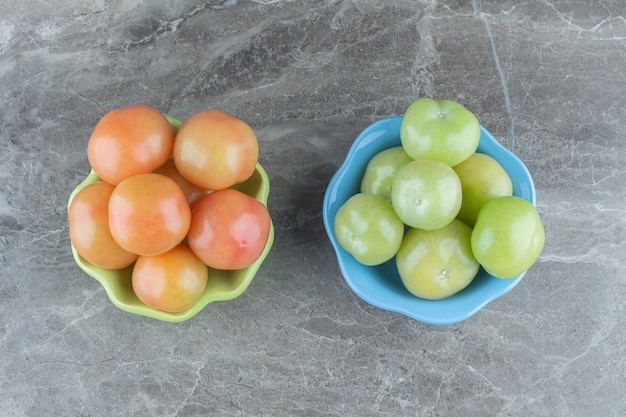 Vue de dessus des tomates vertes et rouges sur fond gris.