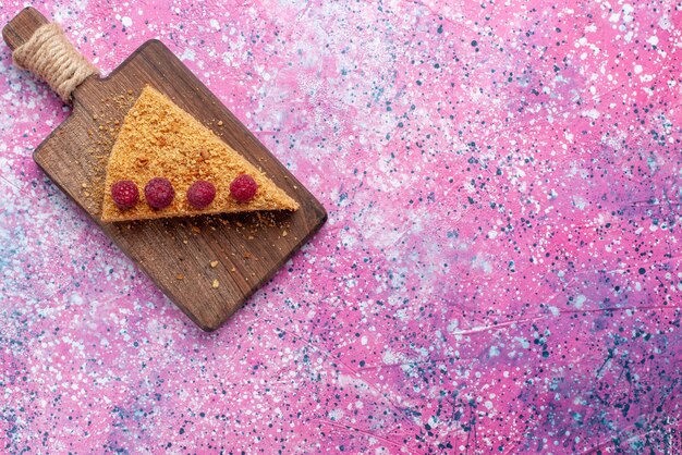 Vue de dessus tranche de gâteau cuit au four et sucré avec des framboises sur un bureau rose vif cuire au four gâteau tarte aux fruits