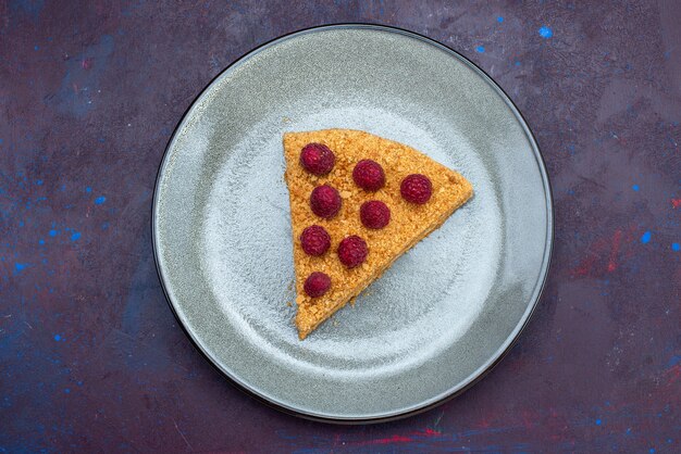 Vue de dessus de la tranche de gâteau délicieux avec des framboises sur une surface sombre