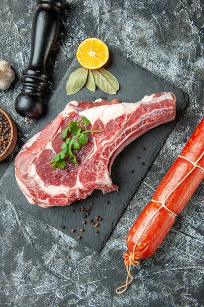 Vue de dessus tranche de viande fraîche avec saucisse sur fond gris clair cuisine animal vache poulet viande nourriture couleur boucher