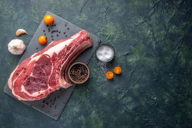 Vue de dessus tranche de viande fraîche viande crue avec du poivre et du sel sur fond sombre repas de poulet photo couleur alimentaire boucher animal