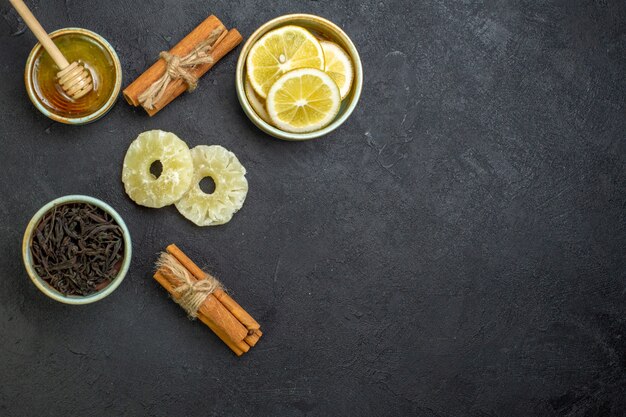 Vue de dessus des tranches de citron avec du miel sur une table sombre