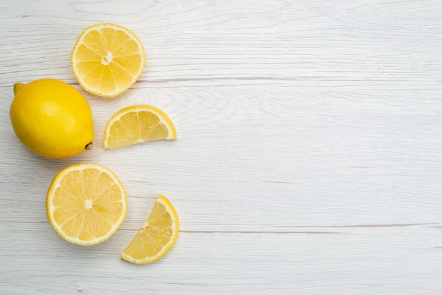 Vue de dessus en tranches de citron frais aigre et juteux sur blanc, jus tropical d'agrumes