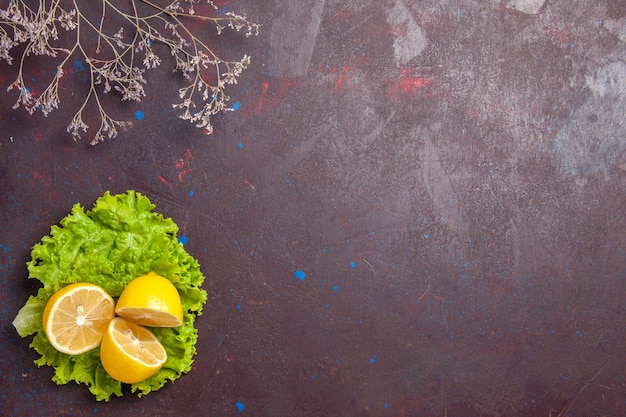 Vue de dessus des tranches de citron frais avec salade verte sur dark