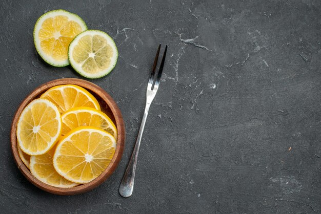 Vue de dessus des tranches de citron frais sur une surface sombre