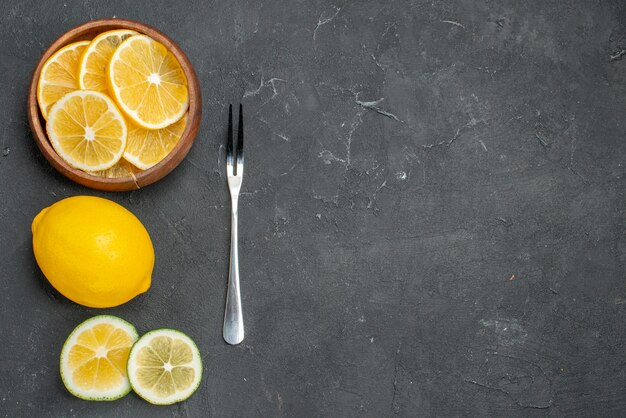 Vue de dessus des tranches de citron frais sur une surface sombre