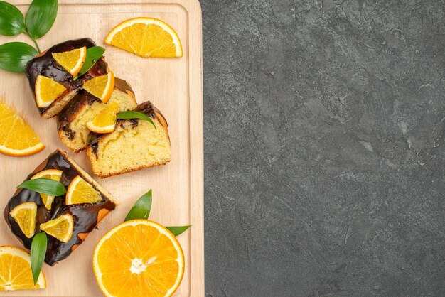 Vue de dessus des tranches de citron frais et des tranches de gâteau hachées sur fond sombre