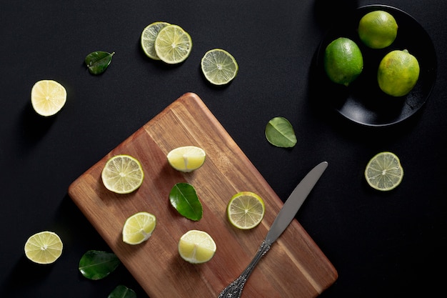 Photo gratuite vue de dessus des tranches de citron vert sur une planche à découper