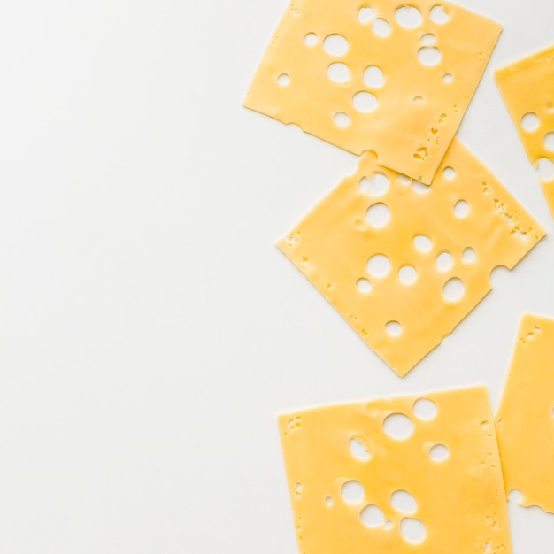 Photo gratuite vue de dessus des tranches de fromage emmental avec espaces de copie