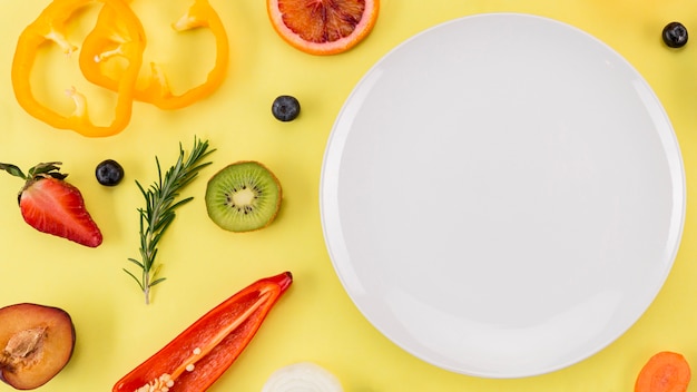 Vue de dessus des tranches de fruits frais et assiette