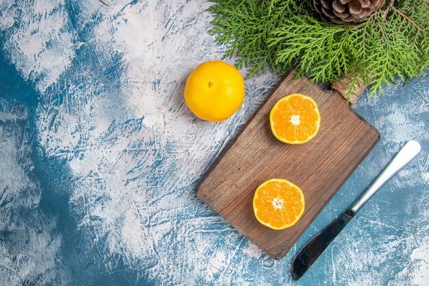 Vue de dessus des tranches de mandarine fraîches sur fond bleu clair