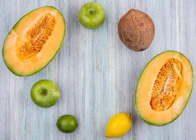 Vue De Dessus Des Tranches De Melon Cantaloup Frais Avec Des Pommes Vertes De Noix De Coco Et Des Citrons Sur Fond Gris Avec Espace Copie