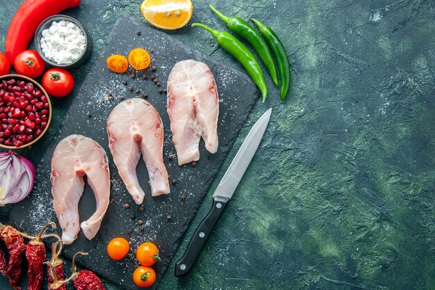 Vue de dessus tranches de poisson frais sur fond sombre plat salade fruits de mer océan viande poivre de mer nourriture eau repas