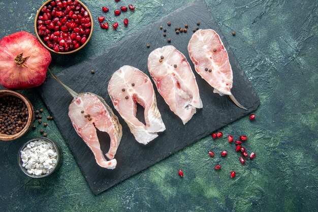 Vue de dessus des tranches de poisson frais sur fond sombre viande de fruits de mer plat de mer eau brute alimentaire poivre de l'océan