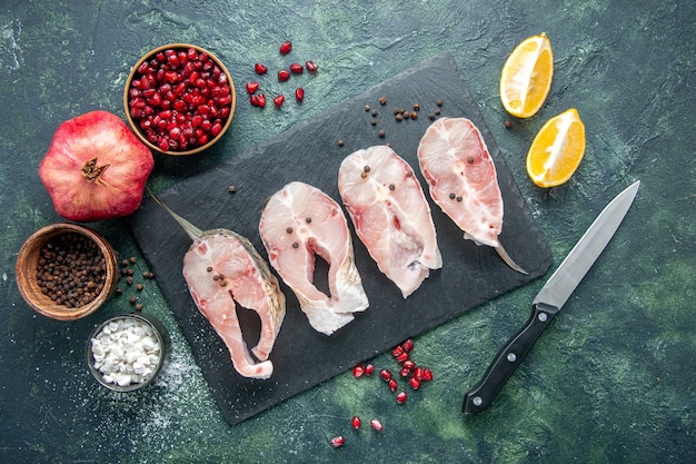 Vue de dessus des tranches de poisson frais sur table sombre viande fruits de mer plat de repas de mer aliments crus océan poivre eau