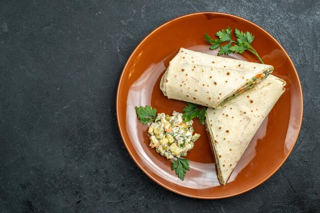 Vue de dessus en tranches shaurma savoureux sandwich à la viande à l'intérieur de la plaque sur la surface sombre burger sandwich pain pita viande