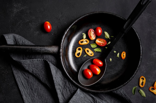 Vue de dessus des tranches de tomates et de piment dans la poêle