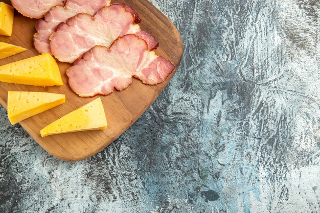 Vue de dessus des tranches de viande tranches de fromage sur une planche à découper sur une surface grise