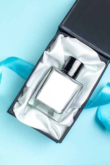 Vue de dessus valentines day parfum présent à l'intérieur du paquet sur la surface bleue couleur mariage couple cadeau parfum femme sentiment