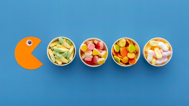 Photo gratuite vue de dessus d'une variété de bonbons dans des tasses