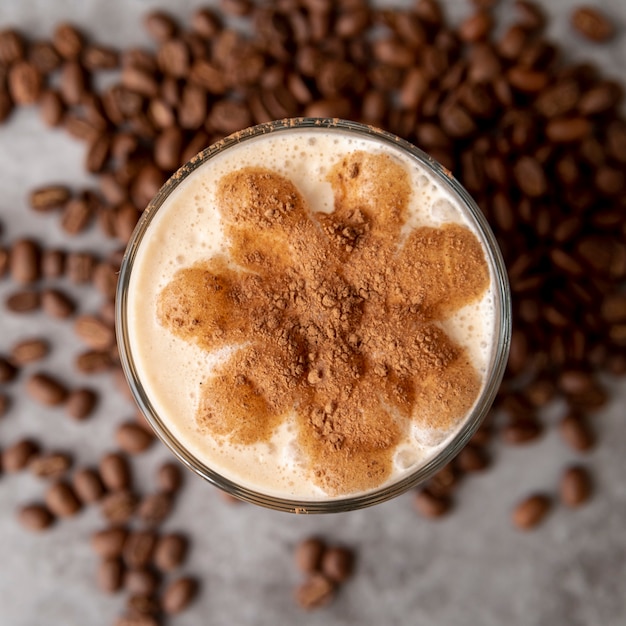 Vue de dessus verre de cappucino avec grains de café