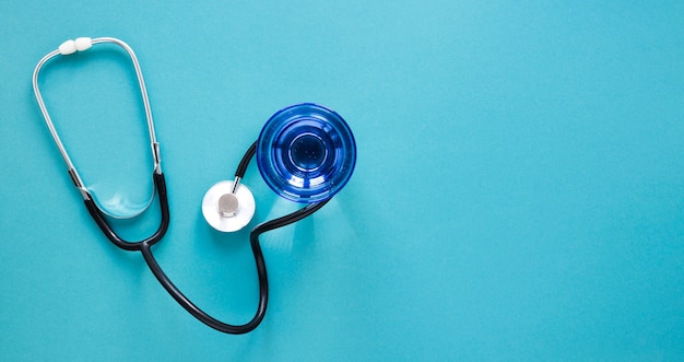 Photo gratuite vue de dessus verre d'eau avec stéthoscope sur la table