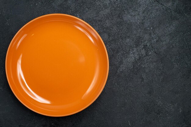 Vue de dessus en verre plat orange vide fabriqué sur la surface sombre