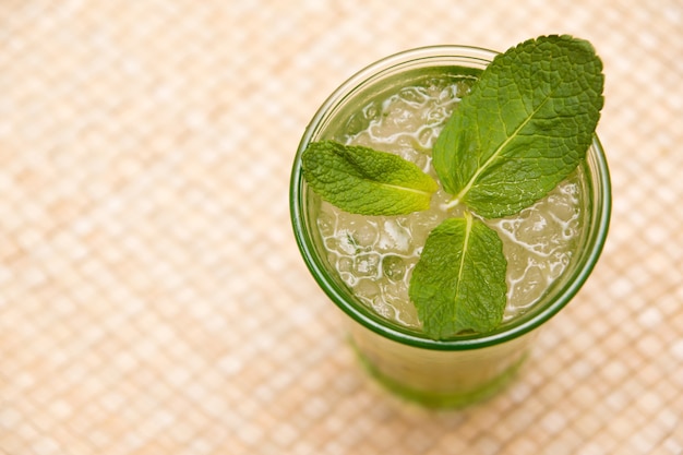 Vue de dessus d'un verre de thé glacé avec des feuilles de menthe sur la table