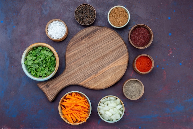 Vue de dessus les verts et les assaisonnements avec des oignons tranchés sur le fond sombre salade alimentaire repas collation de légumes