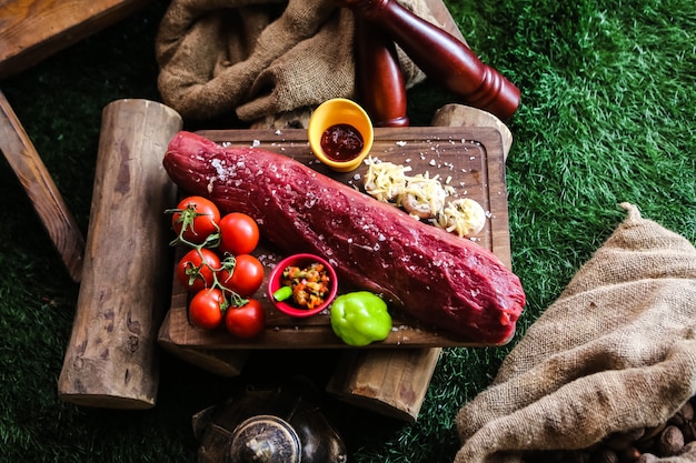 Photo gratuite vue de dessus de la viande crue aux tomates champignons avec fromage poivron et épices sur un plateau