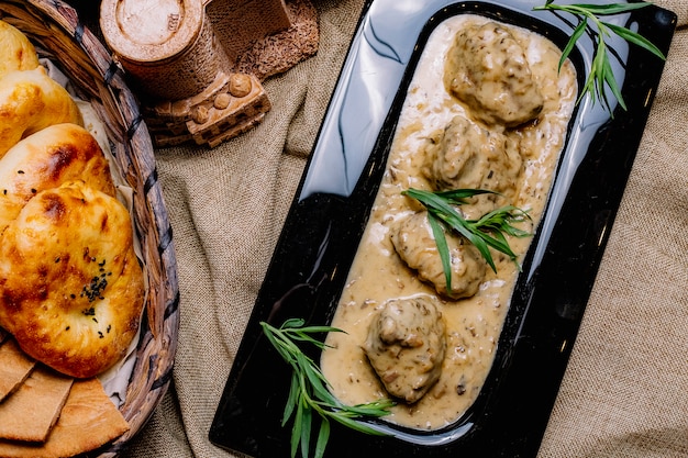 Vue de dessus de la viande dans une sauce aux champignons avec du pain sur la table