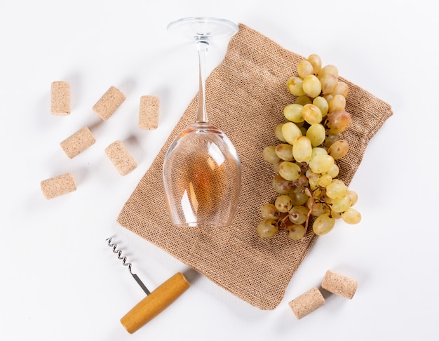 Vue de dessus vin blanc en verre avec raisin sur sac en lin sur blanc horizontal