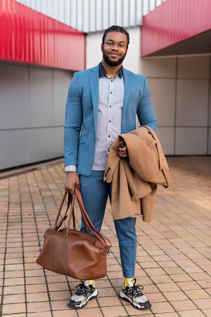 Vue de devant bel homme tenant son sac