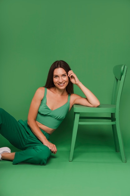 Vue de devant femme posant avec une tenue verte