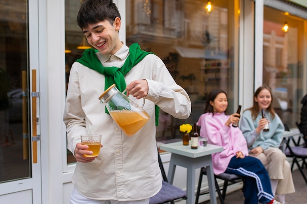 Photo gratuite vue de devant un homme souriant tenant un kombucha