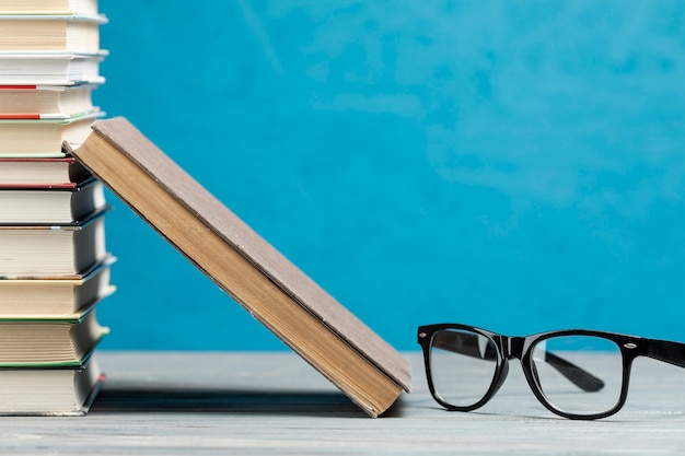 Vue de devant d'une pile de livres avec des lunettes