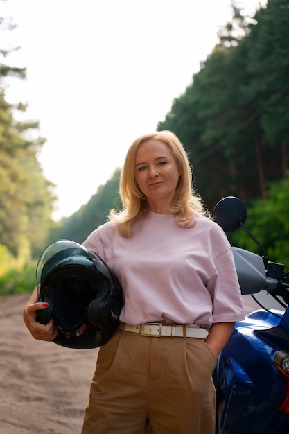 Vue de devant vieille femme cool avec moto