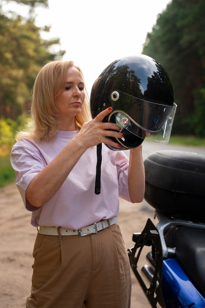 Vue de devant vieille femme cool avec moto