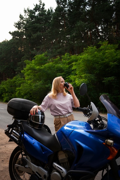 Vue de devant vieille femme cool avec moto