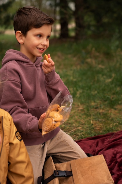 Photo gratuite vue du petit garçon avec sac à dos explorant la nature