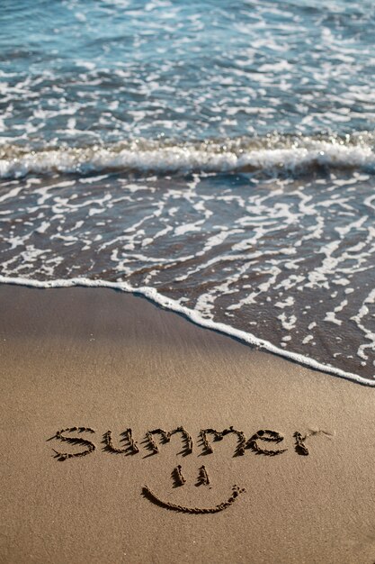 Vue du sable de la plage en été avec un message écrit dessus