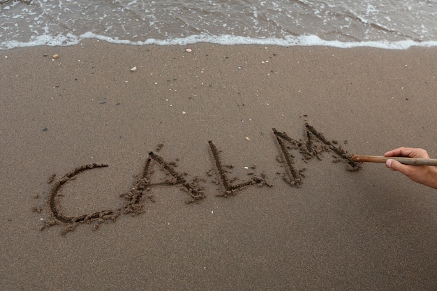 Vue du sable de la plage en été avec un message écrit dessus